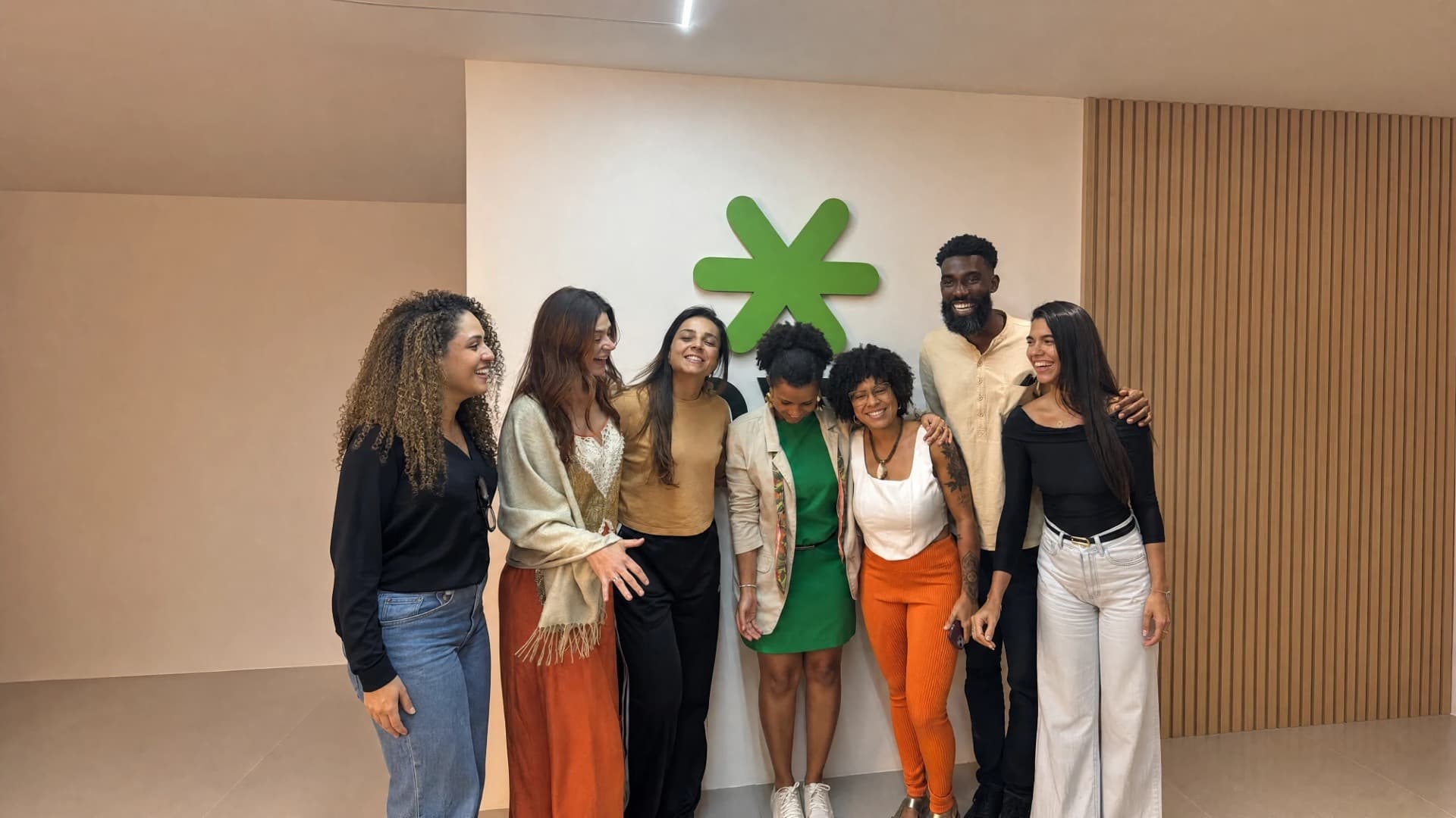 Time da Novak Ads reunido em frente ao asterisco da marca no escritório