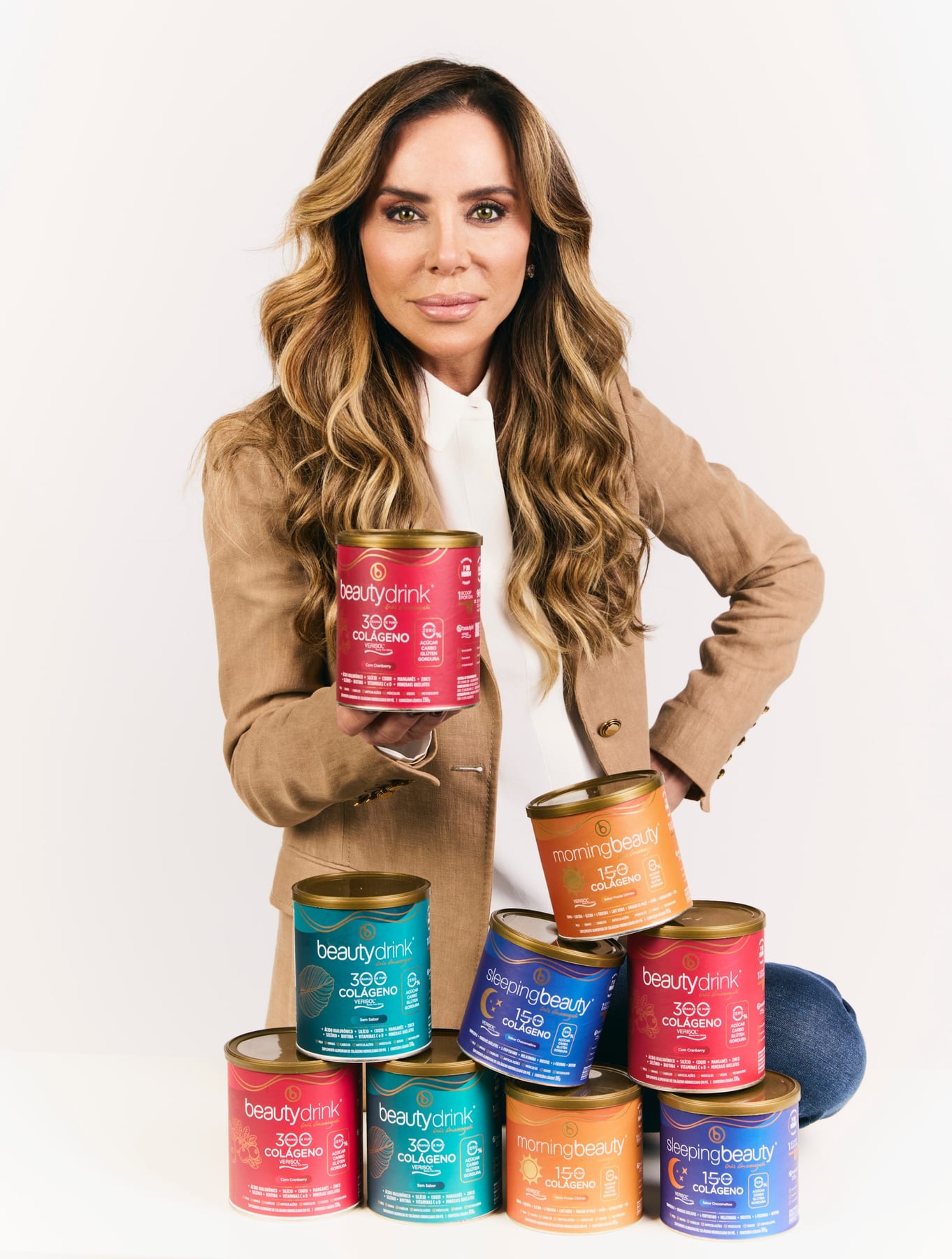 Cris Arcangeli, fundadora da Beautyin, com uma pirâmide de latas de Beautydrink, MorningBeauty e SleepingBeauty